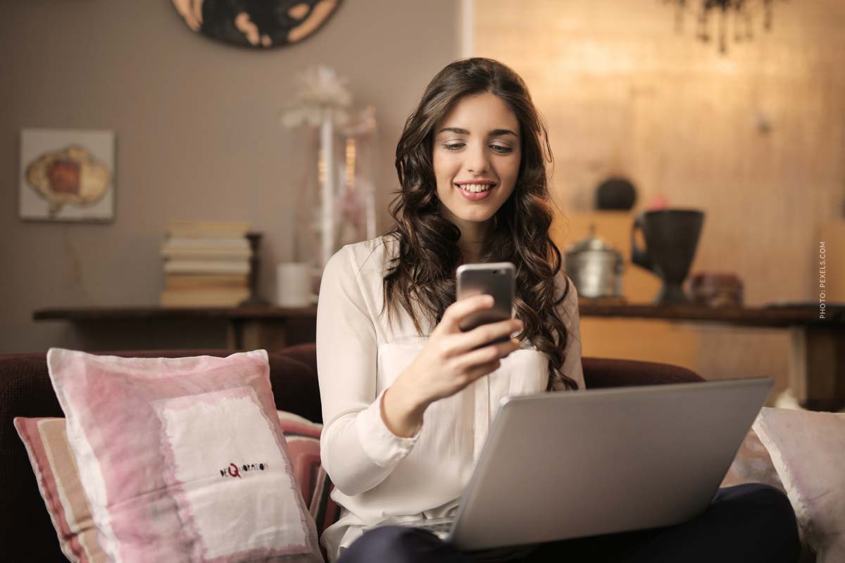 about-you-online-shop-woman-sitting-in-livin-room-with-laptop-and-mobile-phone-online-shopping